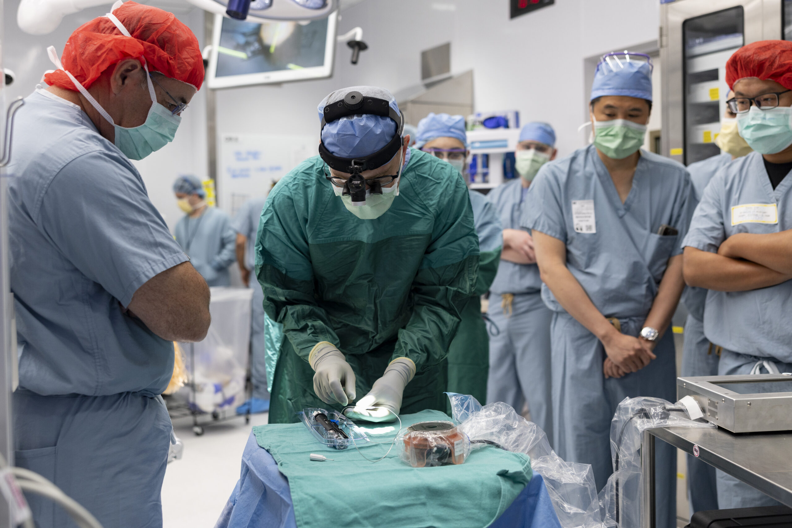 Surgeon prepares brain-computer implant technology while others observe