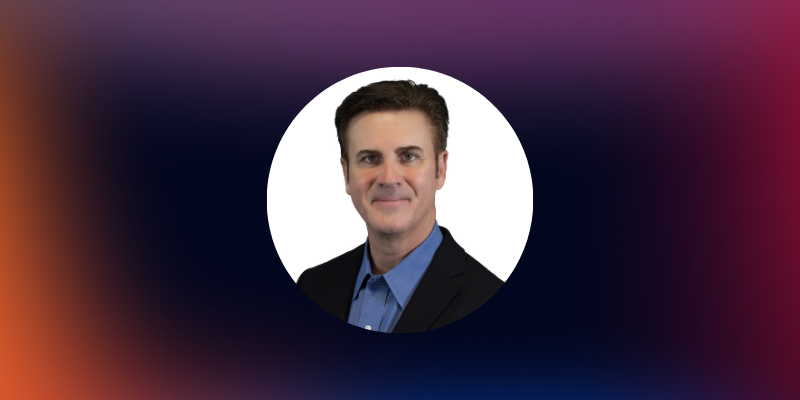 Headshot of Paradromics Chief Clinical Officer Bill Marks over a gradient background